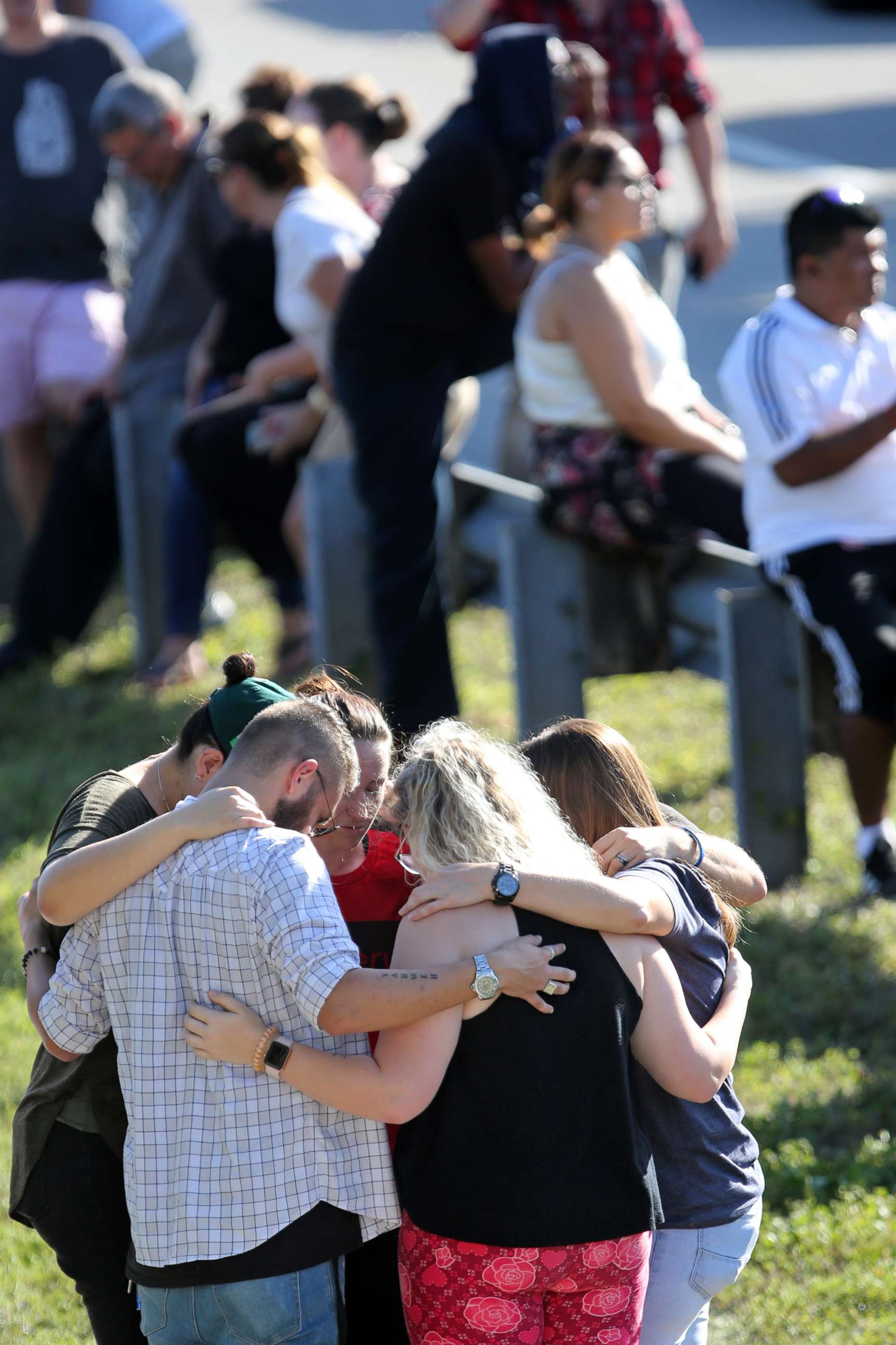 PHOTO: People bow their heads while waiting for word from students at Stoneman Douglas High School in Parkland, Fla., after a shooting on Feb. 14, 2018.