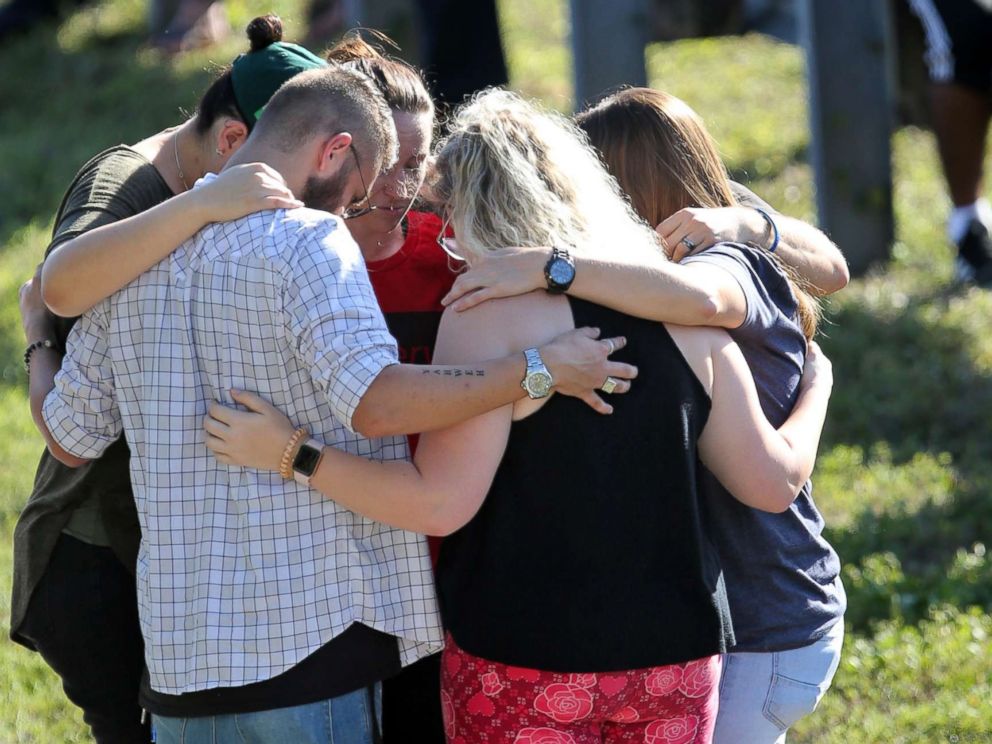 PHOTO: People bow their heads while waiting for word from students at Stoneman Douglas High School in Parkland, Fla., after a shooting on Feb. 14, 2018.