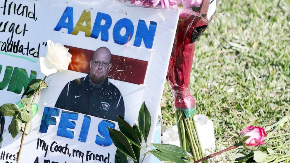 PHOTO: A tribute to coach Aaron Feis is left at the base of a white cross at Pine Trails Park in Parkland, Fla., Feb. 16, 2018. 