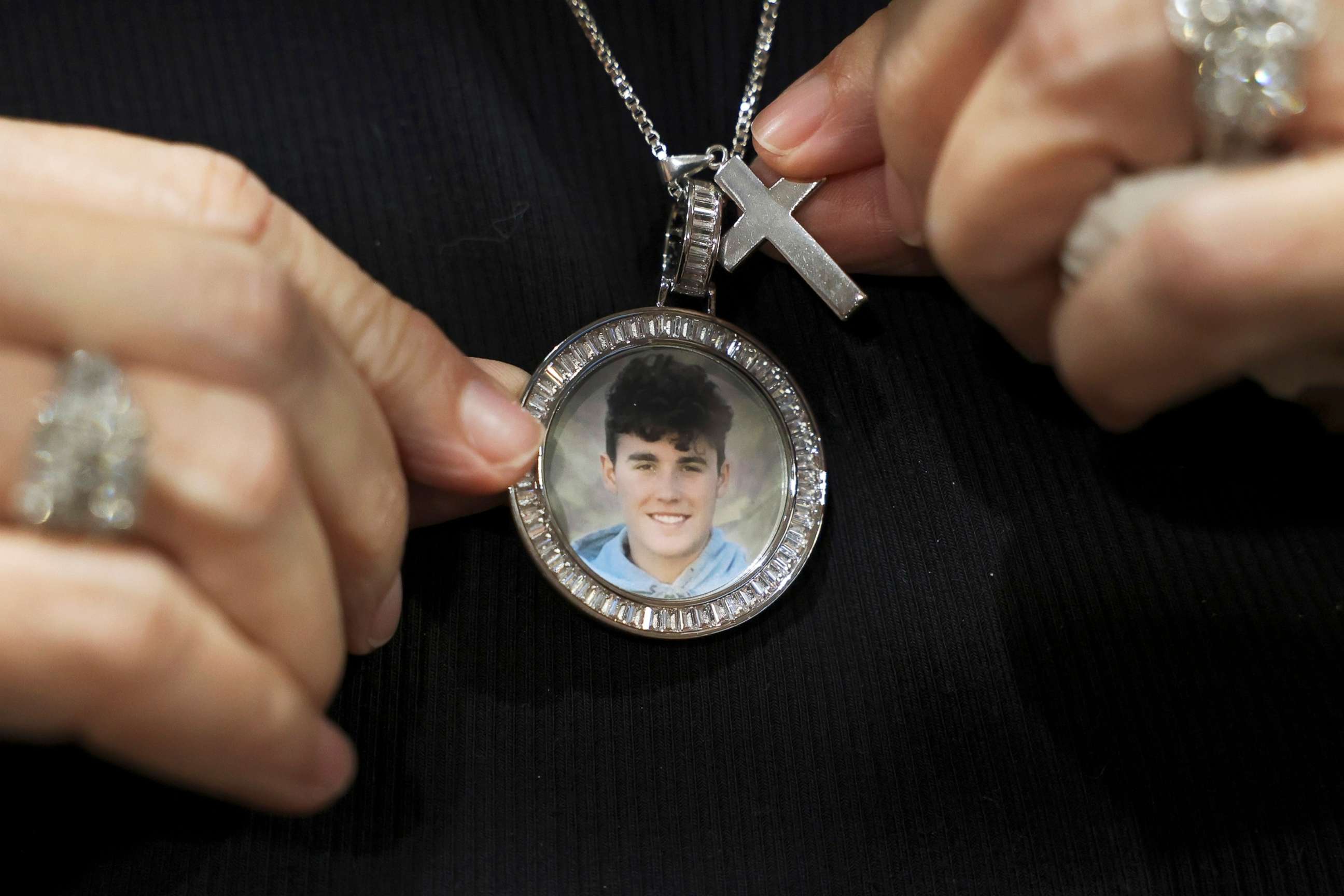 PHOTO: Gena Hoyer shows the pendant given to her by coworkers bearing an image of her son, Luke Hoyer, 15, who was killed in the 2018 Marjory Stoneman Douglas High School shootings in Fort Lauderdale, Fla., Oct. 20, 2021.