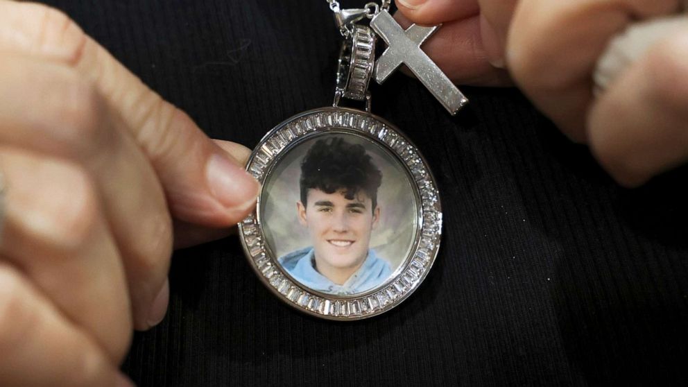 PHOTO: Gena Hoyer shows the pendant given to her by coworkers bearing an image of her son, Luke Hoyer, 15, who was killed in the 2018 Marjory Stoneman Douglas High School shootings in Fort Lauderdale, Fla., Oct. 20, 2021.