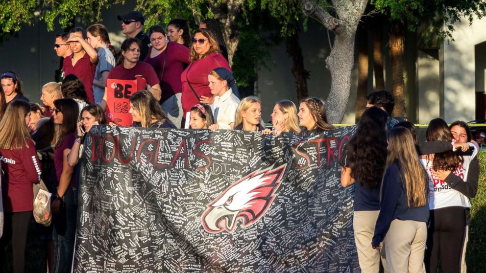 PHOTO: A banner bearing messages is held as parents and students arrive at Marjory Stoneman Douglas High School in Parkland, Fla., Feb. 28, 2018, for the school's reopening, two weeks after the mass shootings at the school.