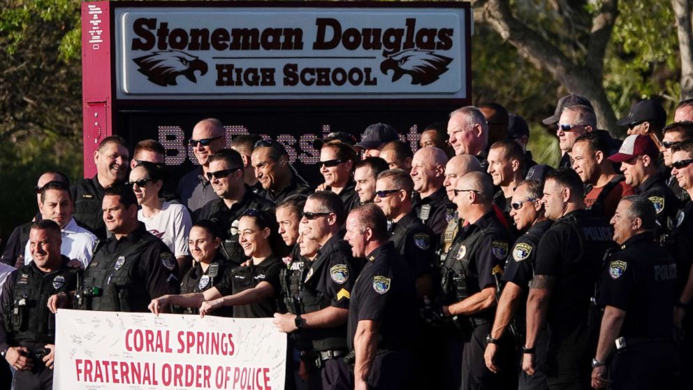 PHOTO: Police pose for a photo after they escorted returning students to Marjory Stoneman Douglas High School in Parkland, Fla., Feb. 28, 2018. 