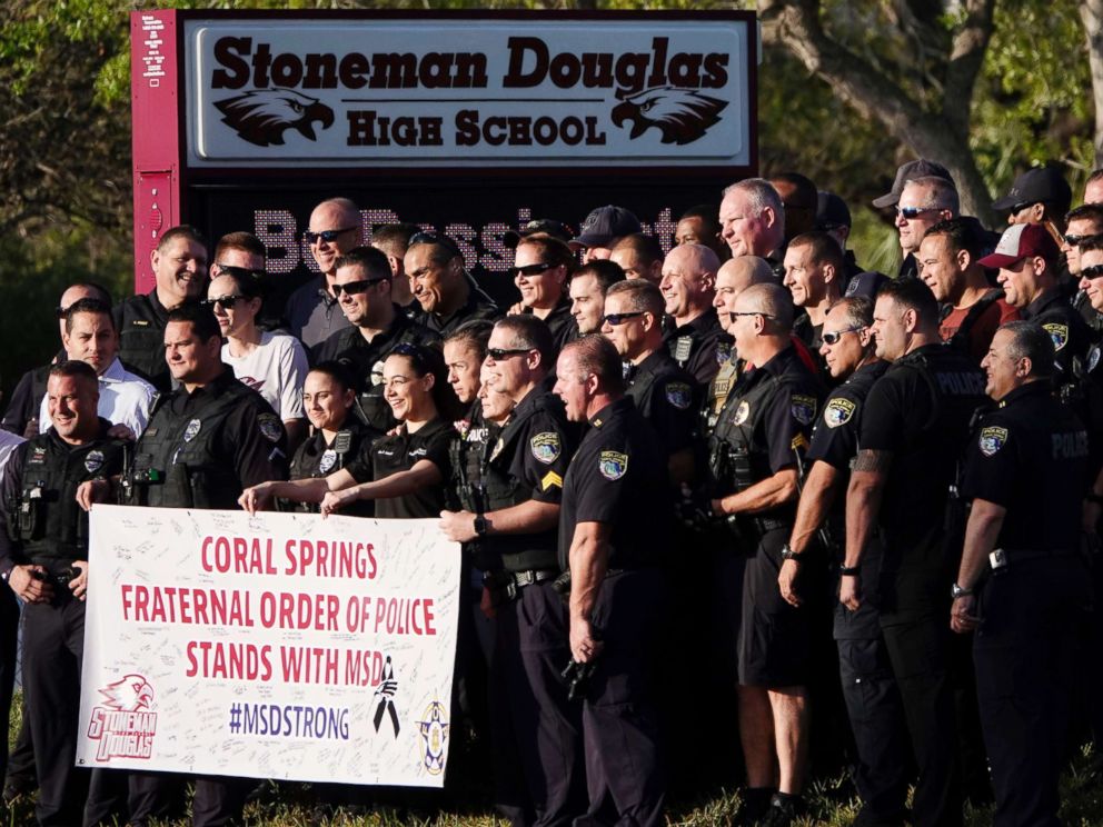 PHOTO: Police pose for a photo after they escorted returning students to Marjory Stoneman Douglas High School in Parkland, Fla., Feb. 28, 2018. 