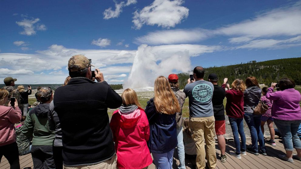 PHOTO: Visitors watch Old Faithful erupt in Yellowstone National Park on June 15, 2020.