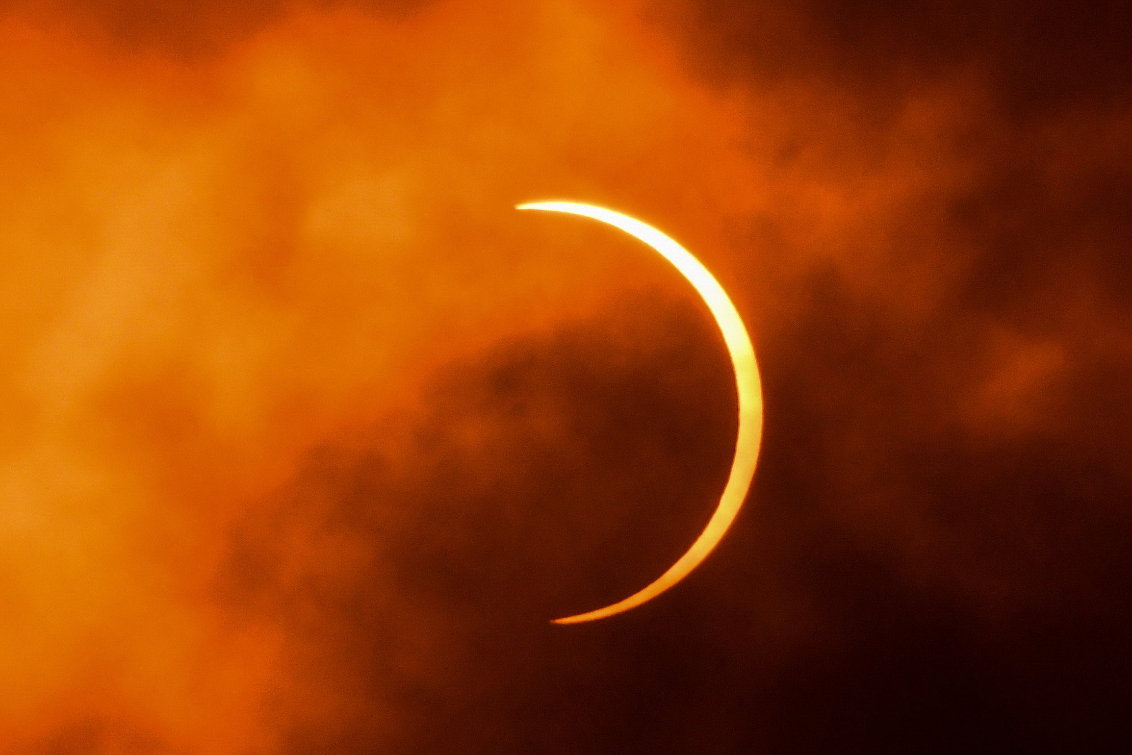 PHOTO: In this June 21, 2020, file photo, the moon moves in front of the sun during an solar eclipse as seen through clouds from New Delhi.