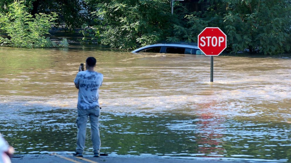 PHOTO: A man takes photos of a submerged car on River Drive in Passaic, N.J., Sept. 2, 2021, after heavy rains from the remnants of Hurricane Ida swept through the northeast.