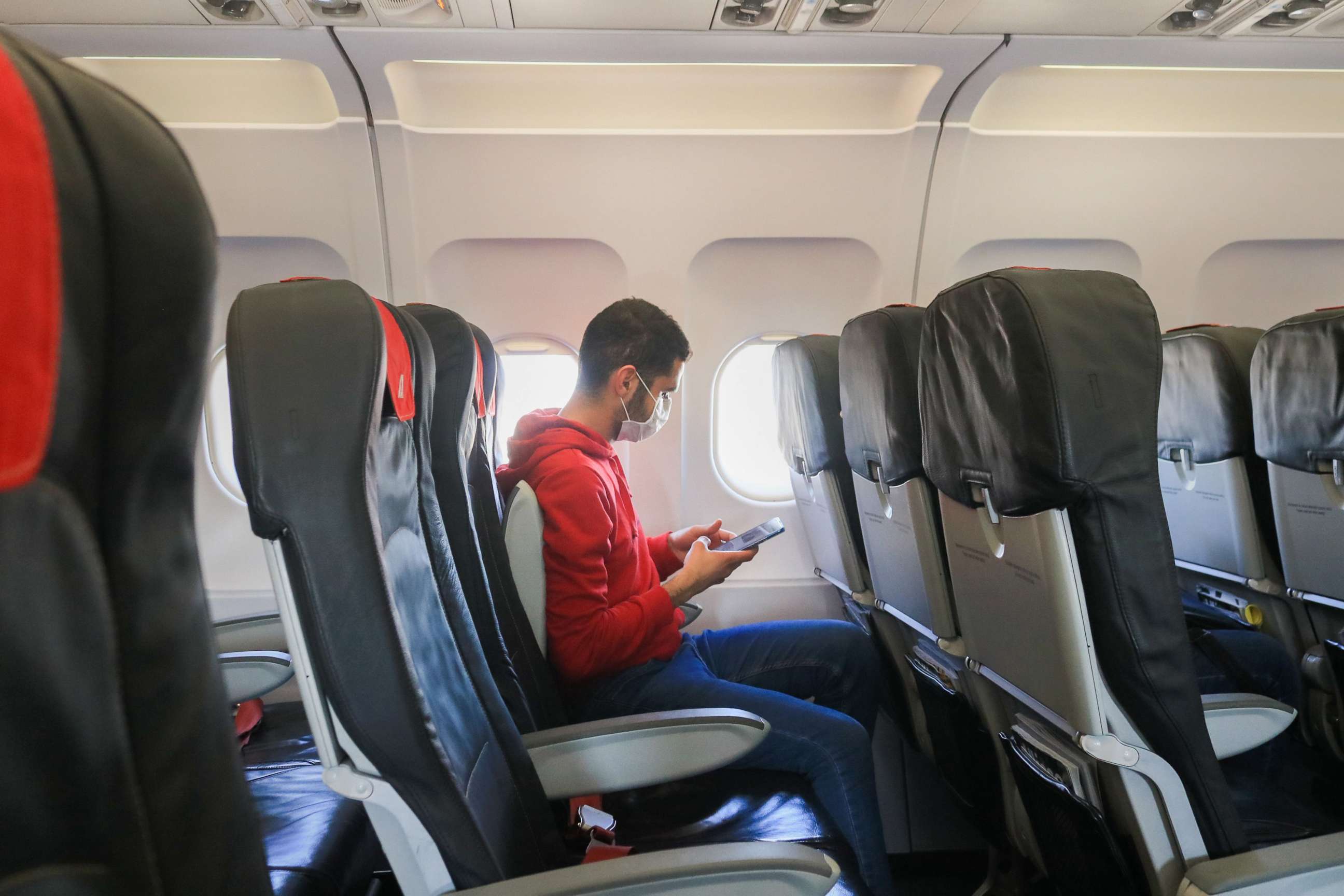 PHOTO: A passenger on board an airplane departing from Fiumicino airport in Rome, Italy wears a face mask against  the novel coronavirus, Feb. 24, 2020.