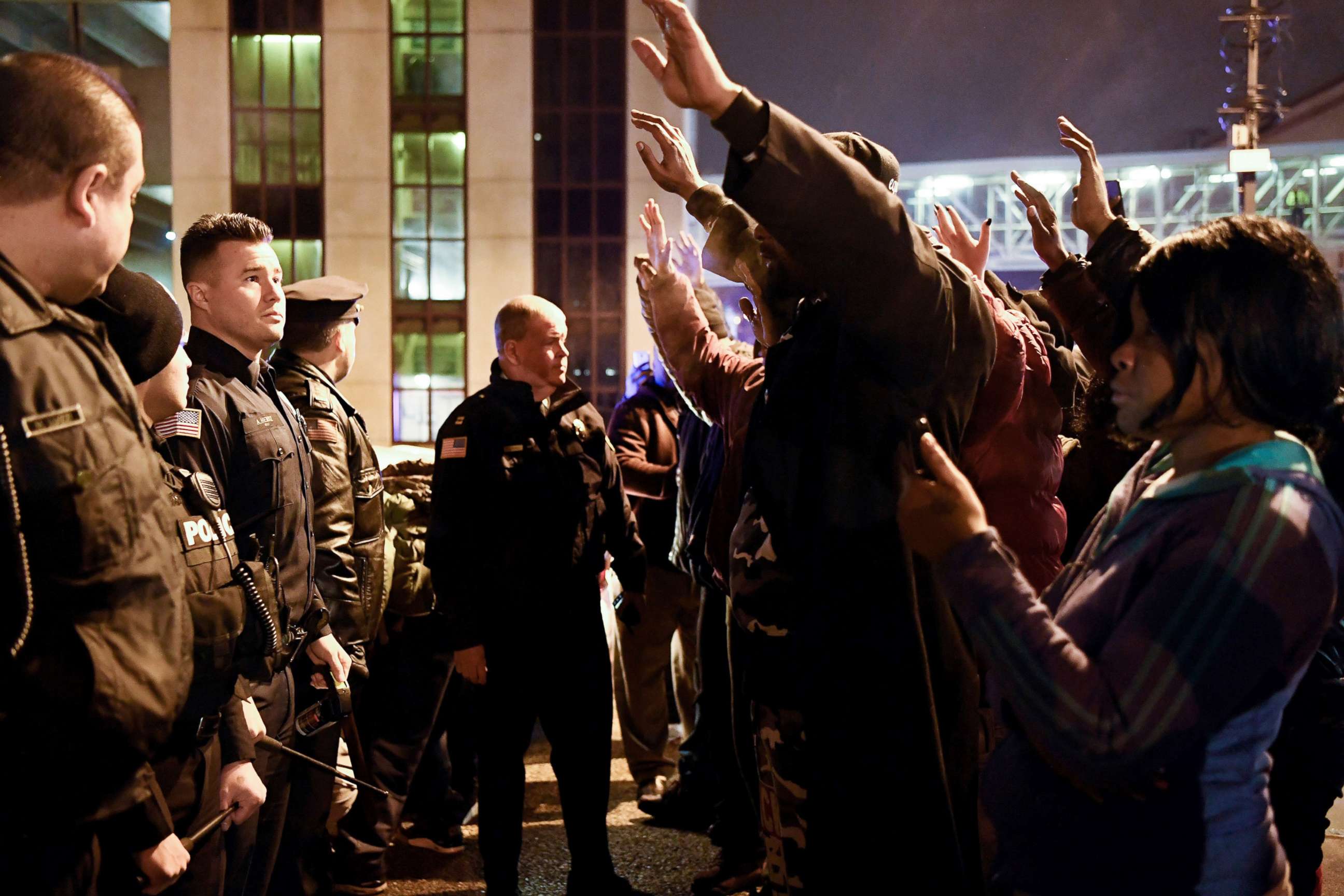 PHOTO: Protesters raise their hands as they face police officers during a rally in reaction to the death of Jameek Lowery, Jan. 8, 2019, in Paterson, N.J. Lowery died after asking the Paterson Police Department for help.