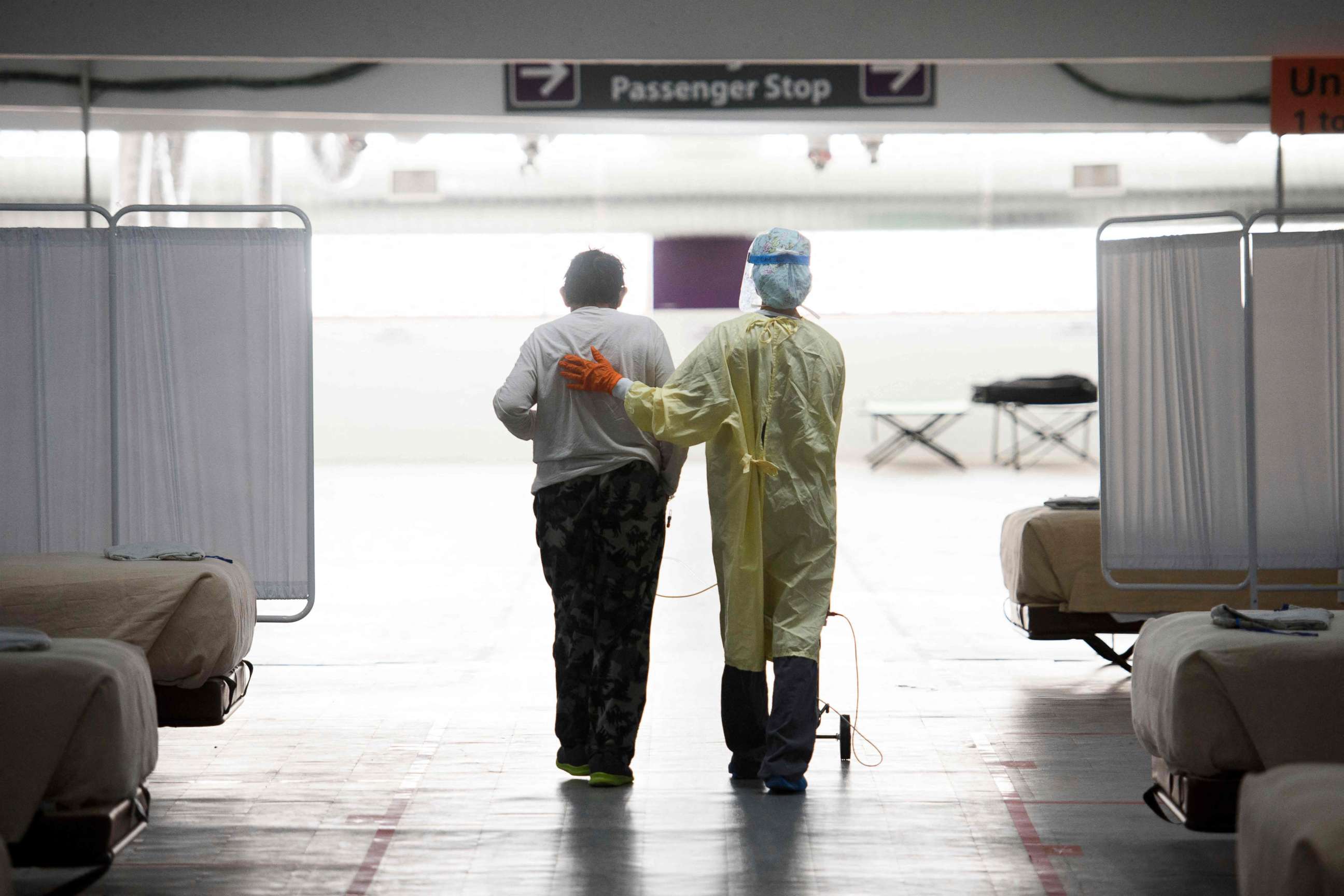 PHOTO: A nurse supports a patient as they walk in the Covid-19 alternative care site, built into a parking garage, at Renown Regional Medical Center, Dec. 16, 2020, in Reno, Nevada.