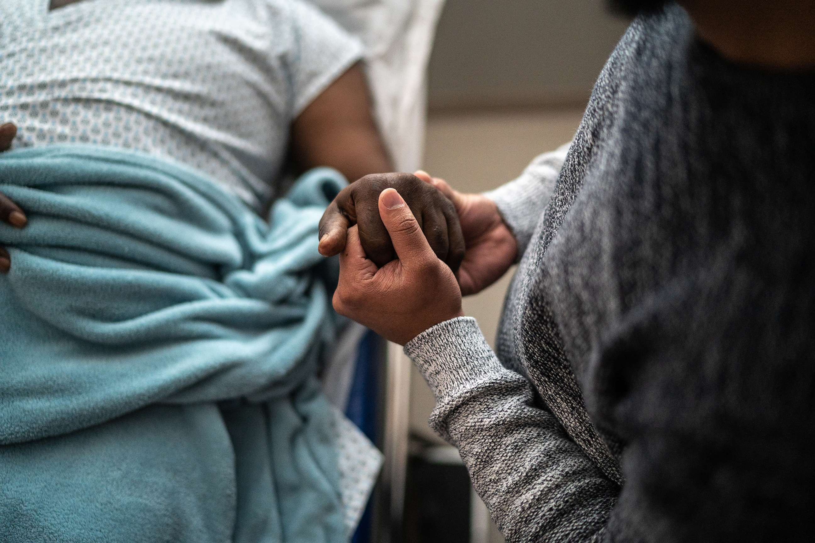 PHOTO: Son holding father's hand at the hospital