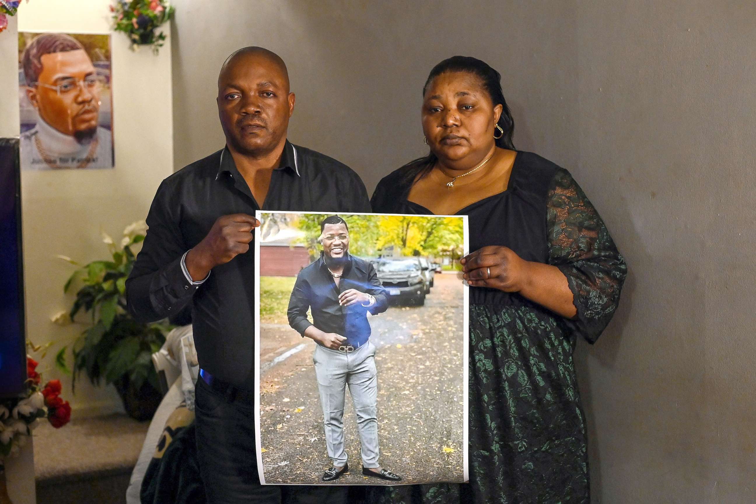 PHOTO: Patrick Lyoyas parents Peter Lyoya (L) and Dorcas Lyoya pose for a portrait as they hold a photo of their son at their home in Lansing, Mich., April 15, 2022. 