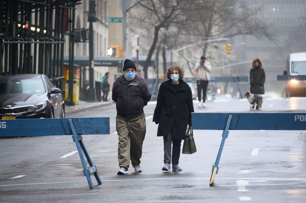 PHOTO: People wear protective face masks while walking in Park Avenue as part of NYC's "Open Streets", which closes some streets to vehicle traffic to allow more space for pedestrians as a restriction to stop the spread of coronavirus on March 29, 2020.