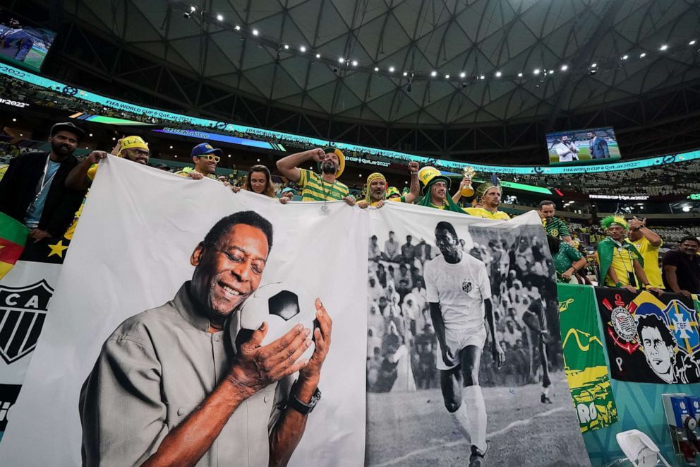PHOTO: Brazilian supporters pose for a picture with Pele's flag before the FIFA World Cup match between Brazil and Cameroon on December 2, 2022 in Lusail, Qatar. 