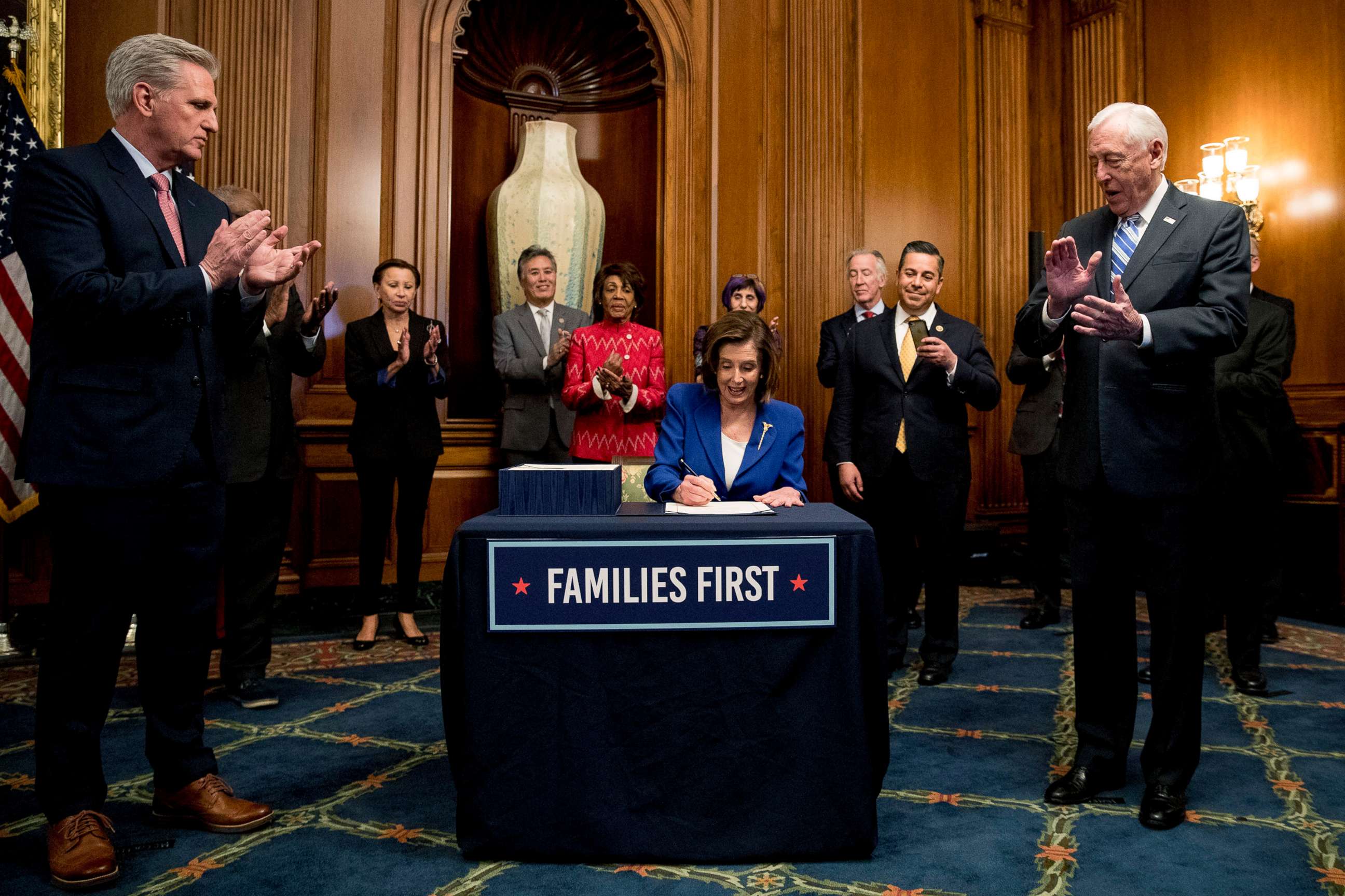 PHOTO: House Speaker Nancy Pelosi, accompanied by House Minority Leader Kevin McCarthy, left, House Majority Leader Steny Hoyer, right, and other bipartisan legislators, signs the Coronavirus Aid, Relief, and Economic Security (CARES) Act.