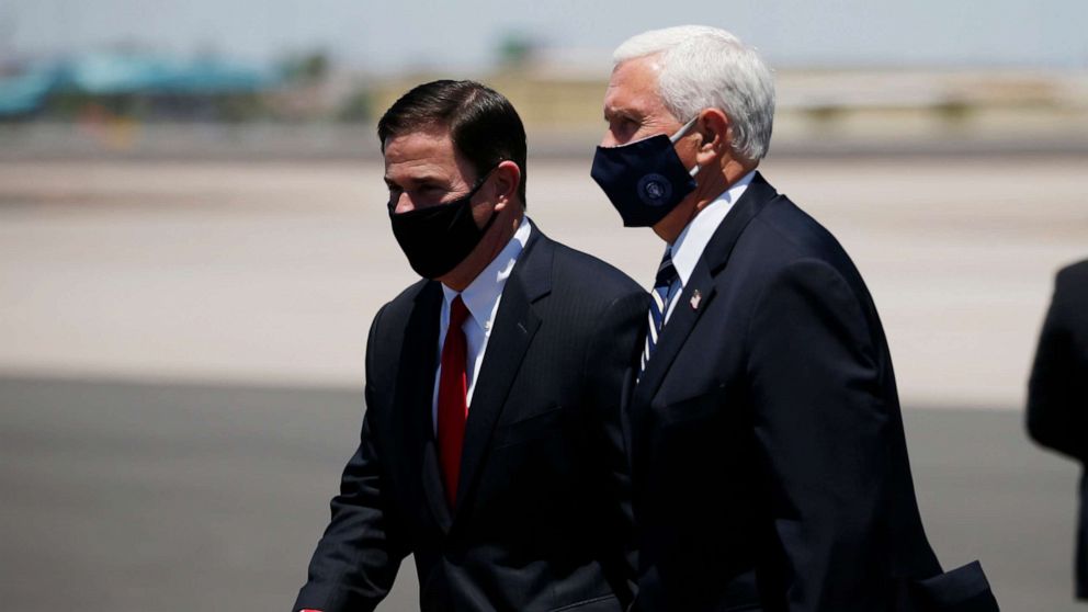 PHOTO: Vice President Mike Pence, right, walks with Arizona Gov. Doug Ducey, left, as the two head to a meeting to discuss the surge in coronavirus cases Wednesday, July 1, 2020, in Phoenix.