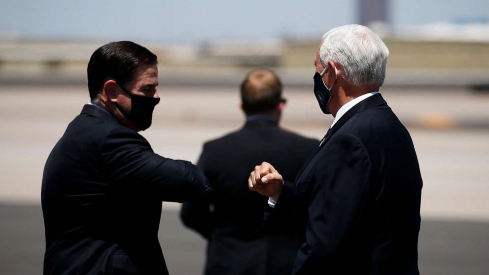 PHOTO: Vice President Mike Pence, right, is greeted with an elbow bump by Arizona Gov. Doug Ducey, left, as he arrives to discuss the surge in coronavirus cases Wednesday, July 1, 2020, in Phoenix.