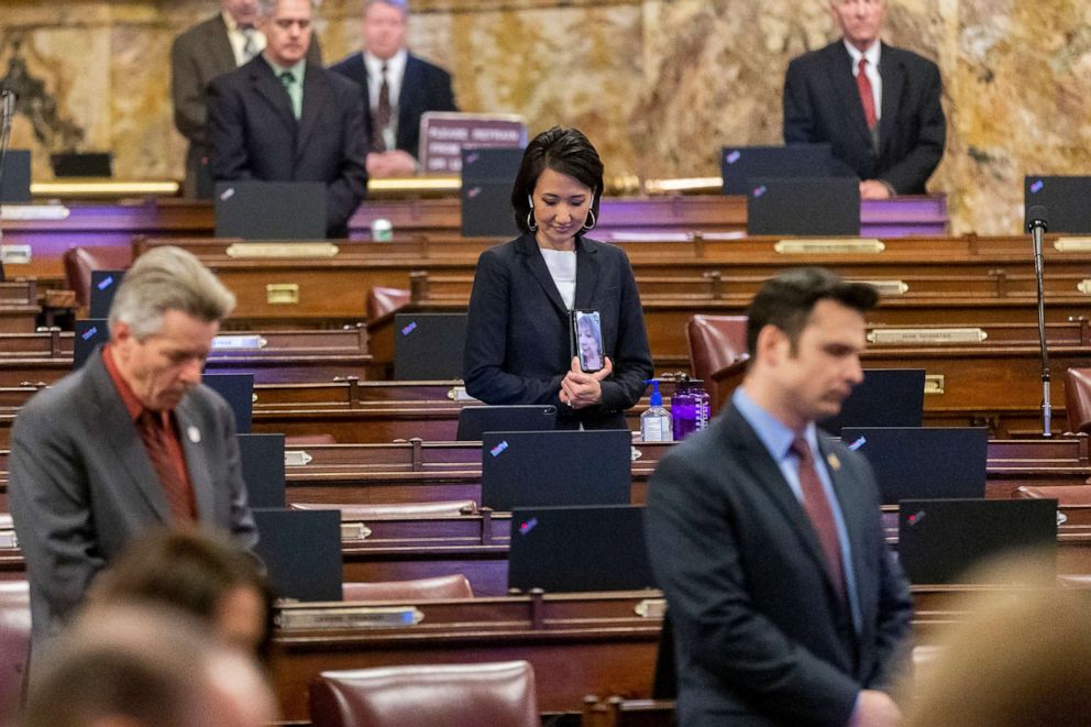 PHOTO: In this March 24, 2020, file photo, Rep. Patty Kim holds her cell phone up so Rep. Maria Donatucci can see the opening prayer as Rep. Russ Diamond and Rep. Andrew Lewis bow their heads at a legislative session at the Capitol in Harrisburg, Pa.