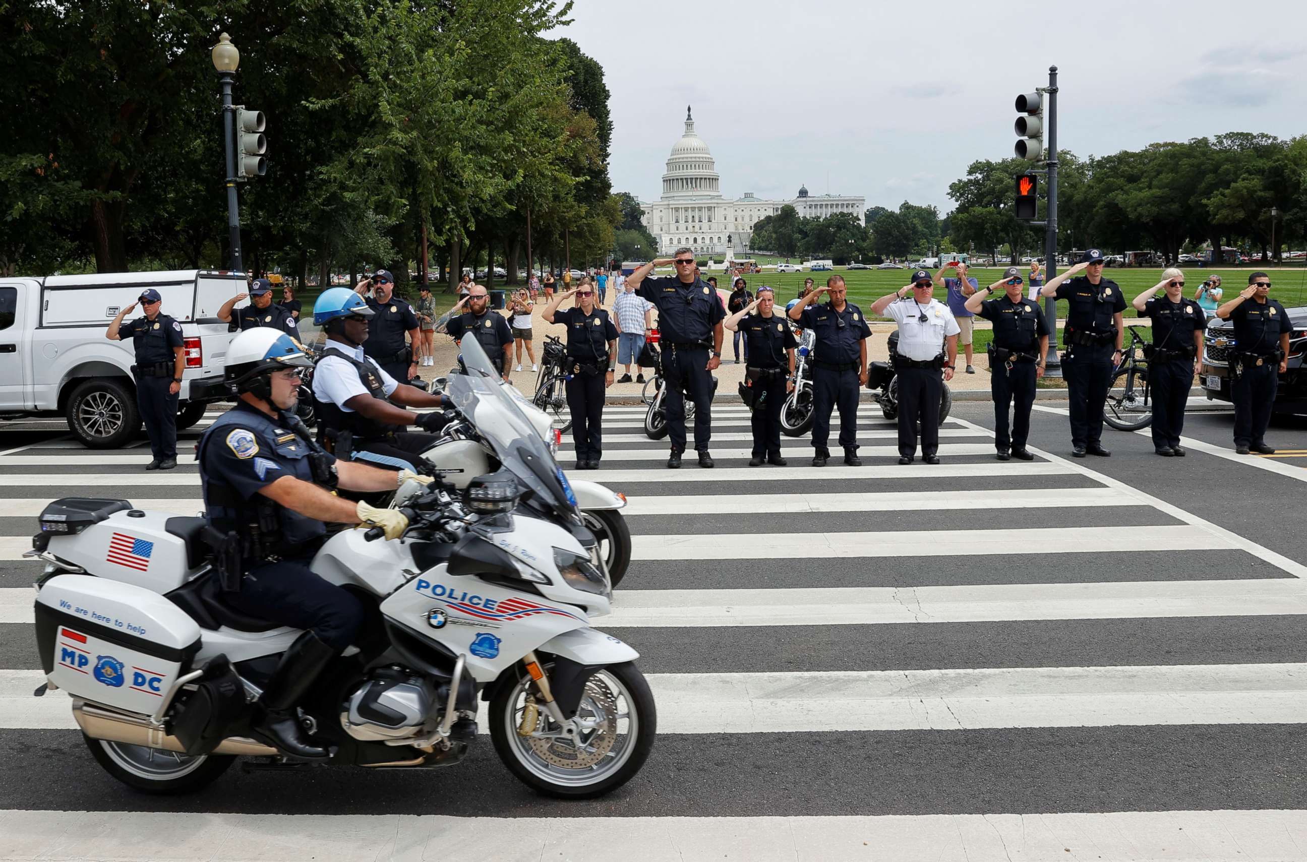 PHOTO: Members of law enforcement agencies in Washington salute as a ceremonial procession in honor of the police officer wounded in a shooting at the Pentagon earlier in the day drives past the U.S. Capitol in Washington, Aug. 3, 2021.