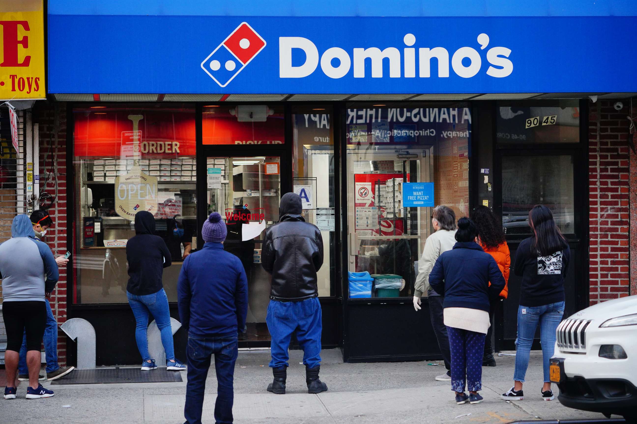 PHOTO: People stand in line outside of a pizza restaurant in Queens, New York, April 12, 2020.