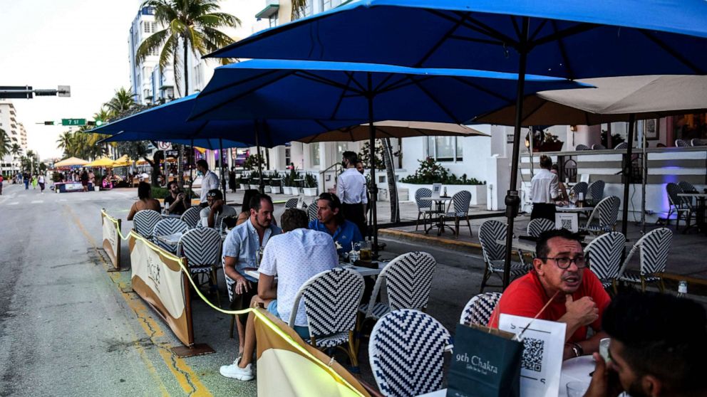 PHOTO: People eat in the outdoor dining area of a restaurant on Ocean Drive in Miami Beach, Florida, on June 24, 2020.