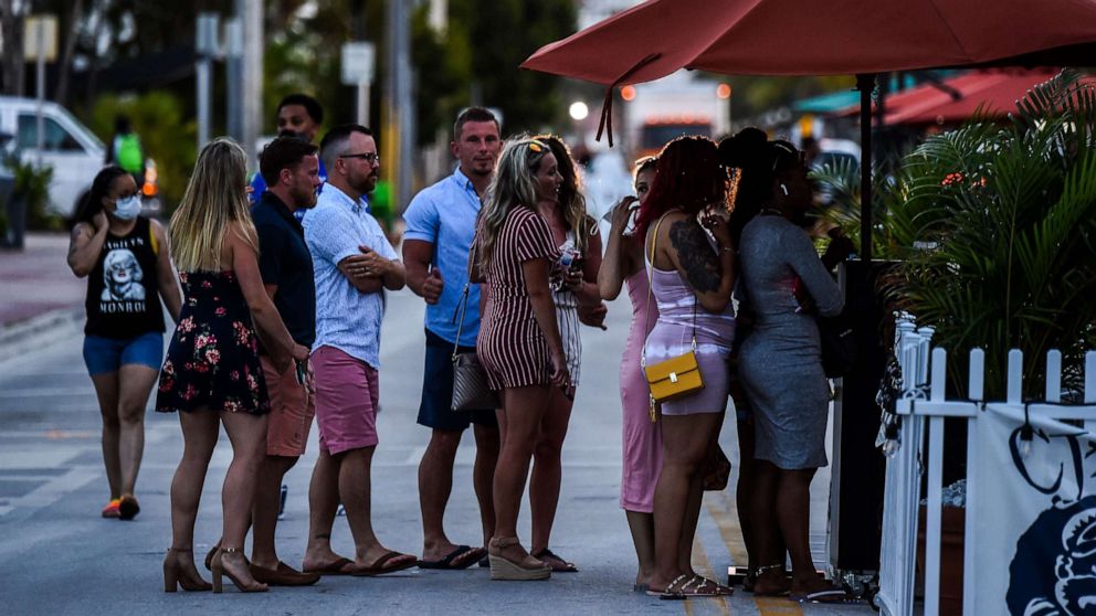 PHOTO: People stand in queue to enter a restaurant on Ocean Drive in Miami Beach, Florida, on June 26, 2020.