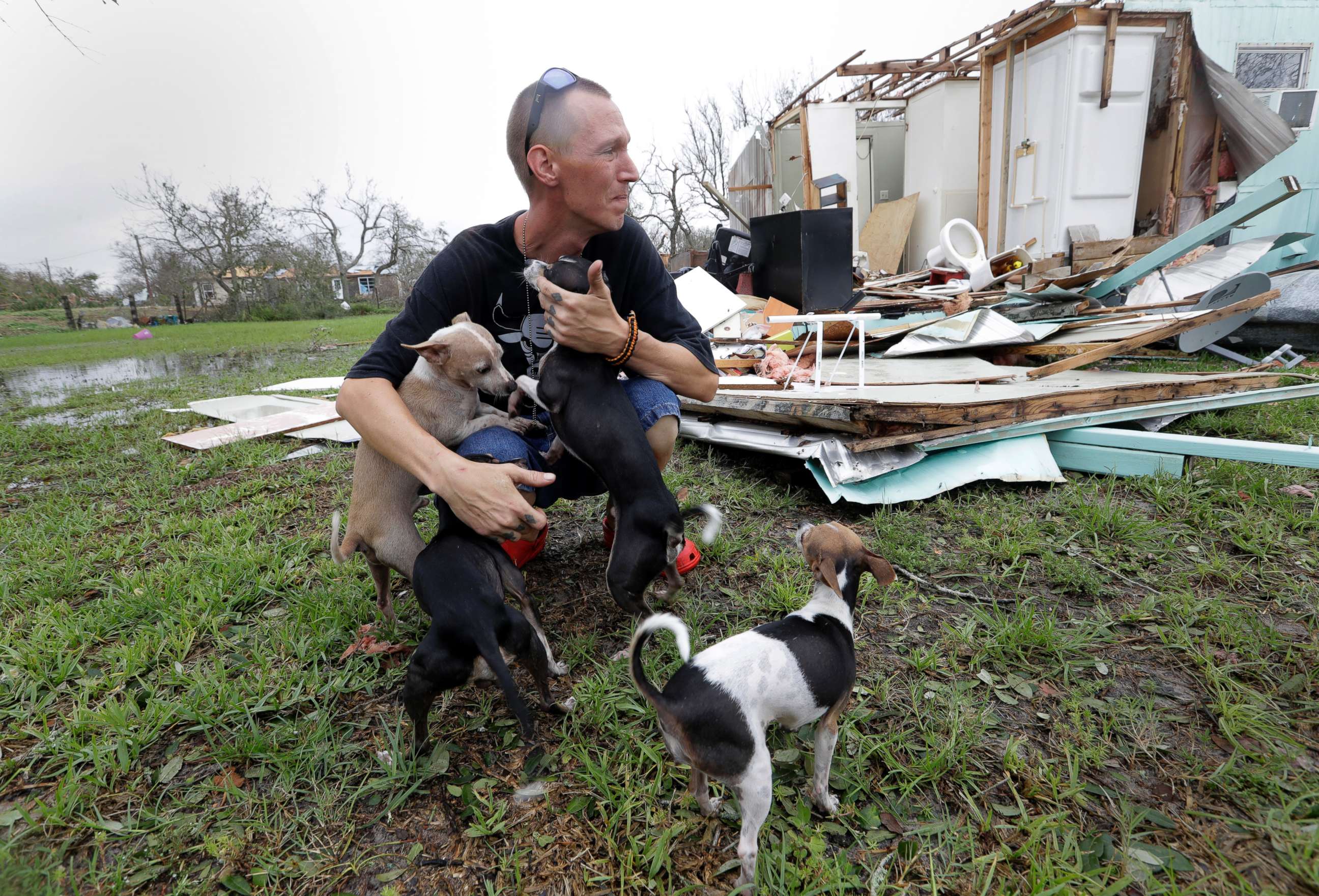 PHOTO: Sam Speights tries to hold back tears while holding his dogs and surveying the damage to his home in the wake of Hurricane Harvey, Aug. 27, 2017, in Rockport, Texas.