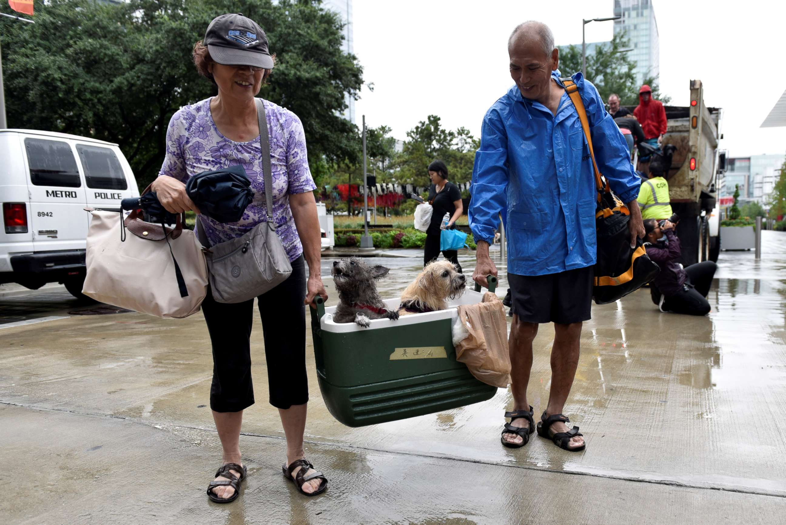 PHOTO: A couple of evacuees carry their dogs into the the George R. Brown Convention Center after Hurricane Harvey inundated the Texas Gulf coast with rain causing widespread flooding, in Houston, Aug. 27, 2017. 