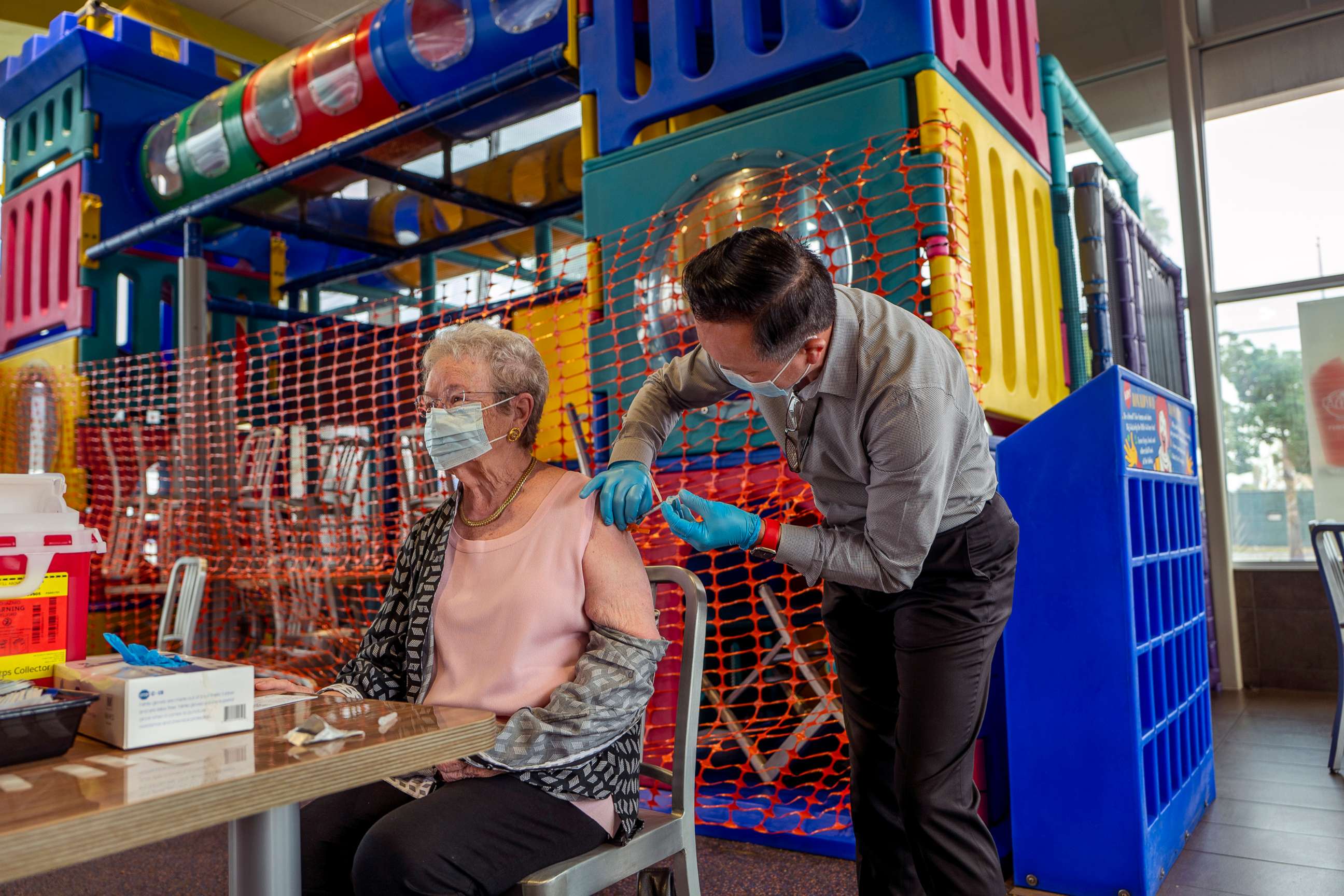 PHOTO: Pharmacist Ryan Le, right, gives Wanda Shaffer, 83, a booster shot of Pfizer-BioNTech's COVID-19 vaccine at McDonalds on Sept. 27, 2021, in Fullerton, Calif.