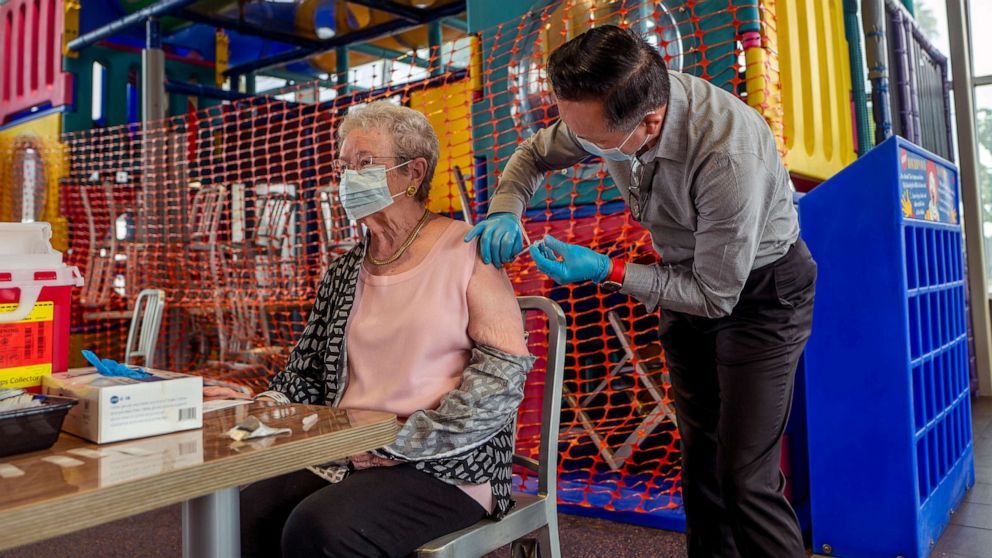 PHOTO: Pharmacist Ryan Le, right, gives Wanda Shaffer, 83, a booster shot of Pfizer-BioNTech's COVID-19 vaccine at McDonalds on Sept. 27, 2021, in Fullerton, Calif.