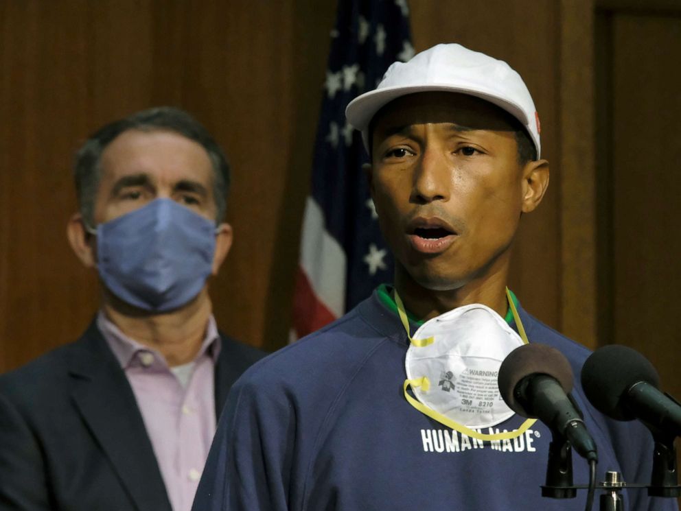 PHOTO: Performing artist and Virginia native Pharrell Williams, right, speaks about the plan to make Juneteenth a state holiday as Virginia Gov. Ralph Northam, left, listens during a press briefing in Richmond, Va., Tuesday, June 16, 2020.