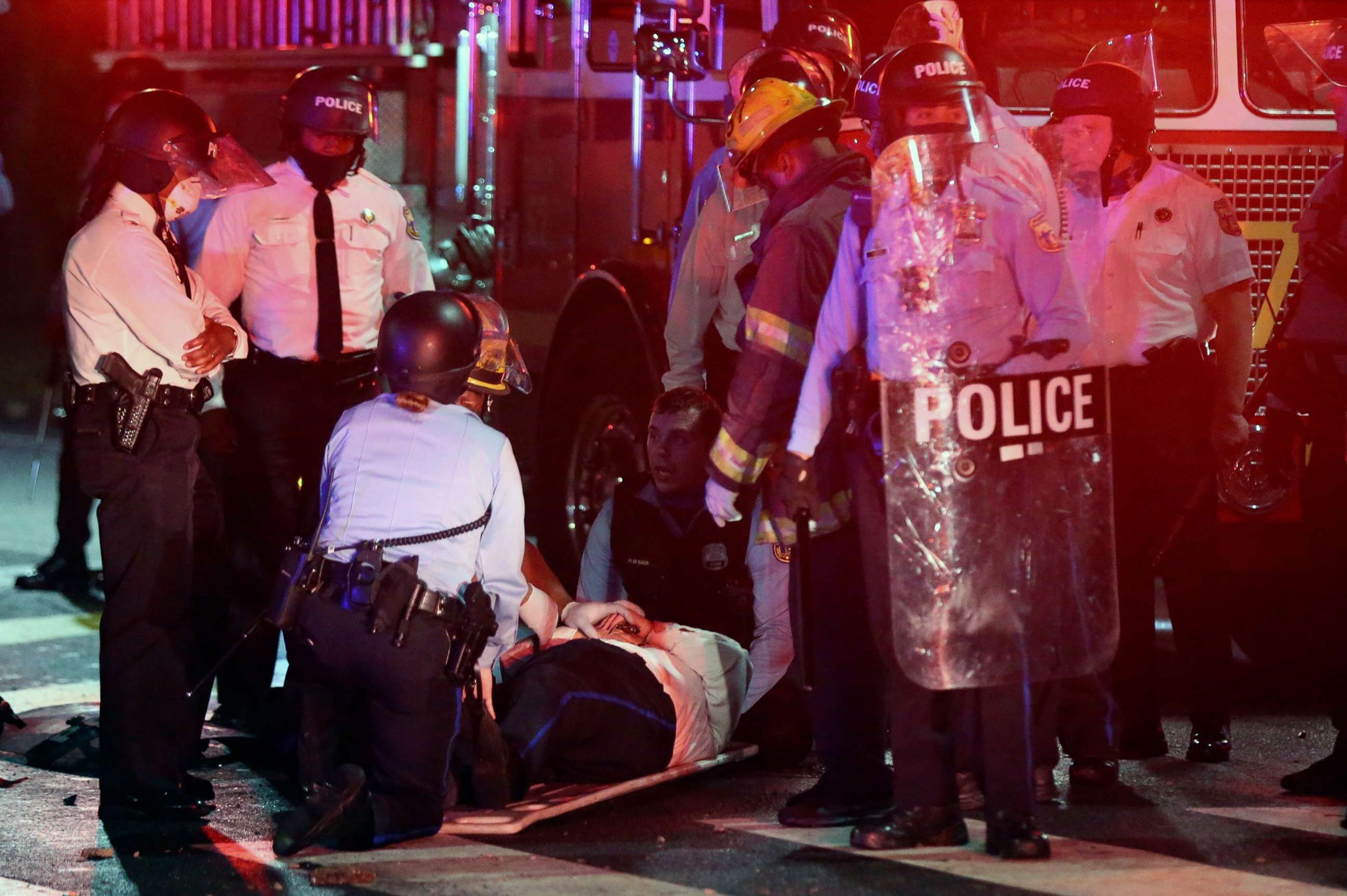 PHOTO: A police officer lies on the ground before being loaded into an ambulance on 52nd Street in West Philadelphia, Oct. 27, 2020.