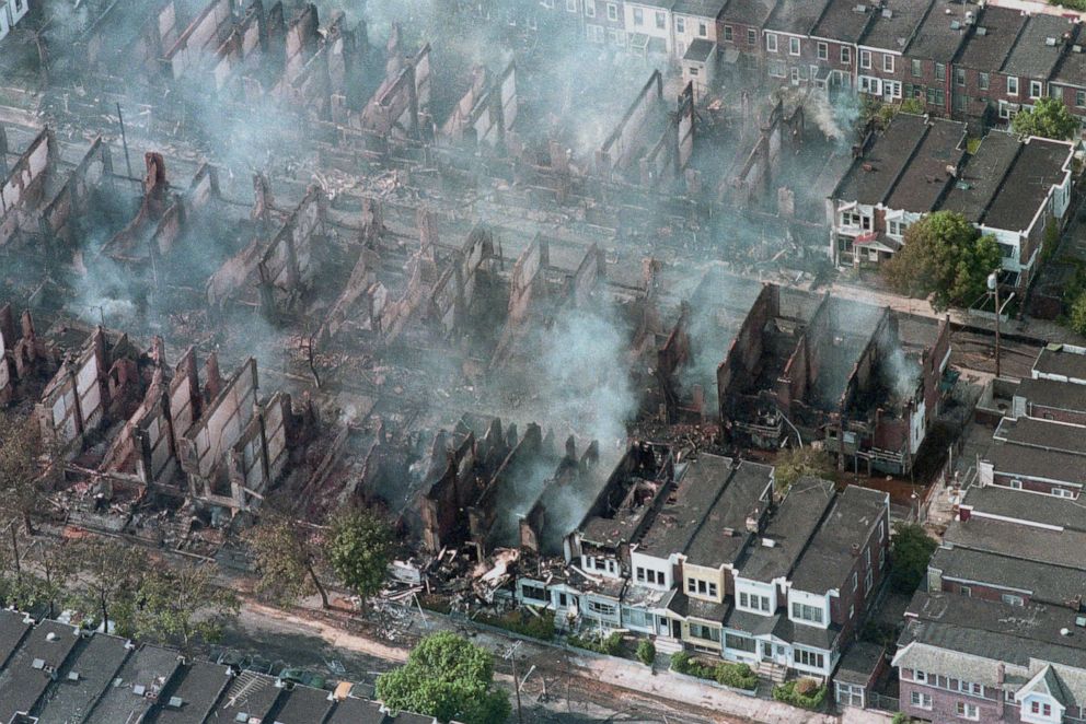 PHOTO: Smoke rises from smoldering rubble on May 14, 1985, where some 60 homes were destroyed by fire after a shoot out and bombing by police at the MOVE organization's house in West Philadelphia while police were attempting to force the group's eviction.