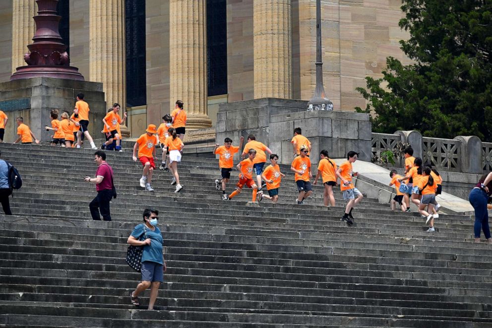 PHOTO: Students on a field trip run up and down the Rocky Steps at the Philadelphia Museum of Art as haze and smoke caused by wildfires in Canada hang over the Philadelphia skyline on June 8, 2023.