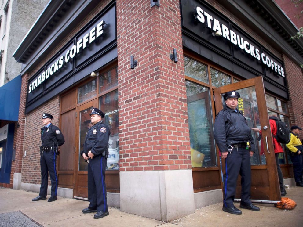 PHOTO: Police officers monitor activity outside as protestors demonstrate inside a Center City Starbucks, where two black men were arrested, in Philadelphia, April 16, 2018.