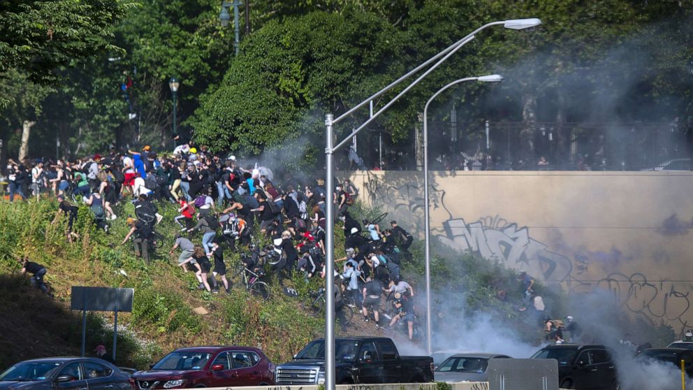 PHOTO: Protesters race up a hill alongside I-676 after being shot by tear gas after a march through Center City on June 1, 2020 in Philadelphia.
