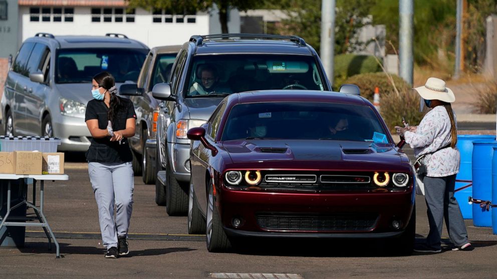 PHOTO: Healthcare workers perform COVID-19 tests at a drive-thru testing center, Dec. 8, 2020, in Phoenix.