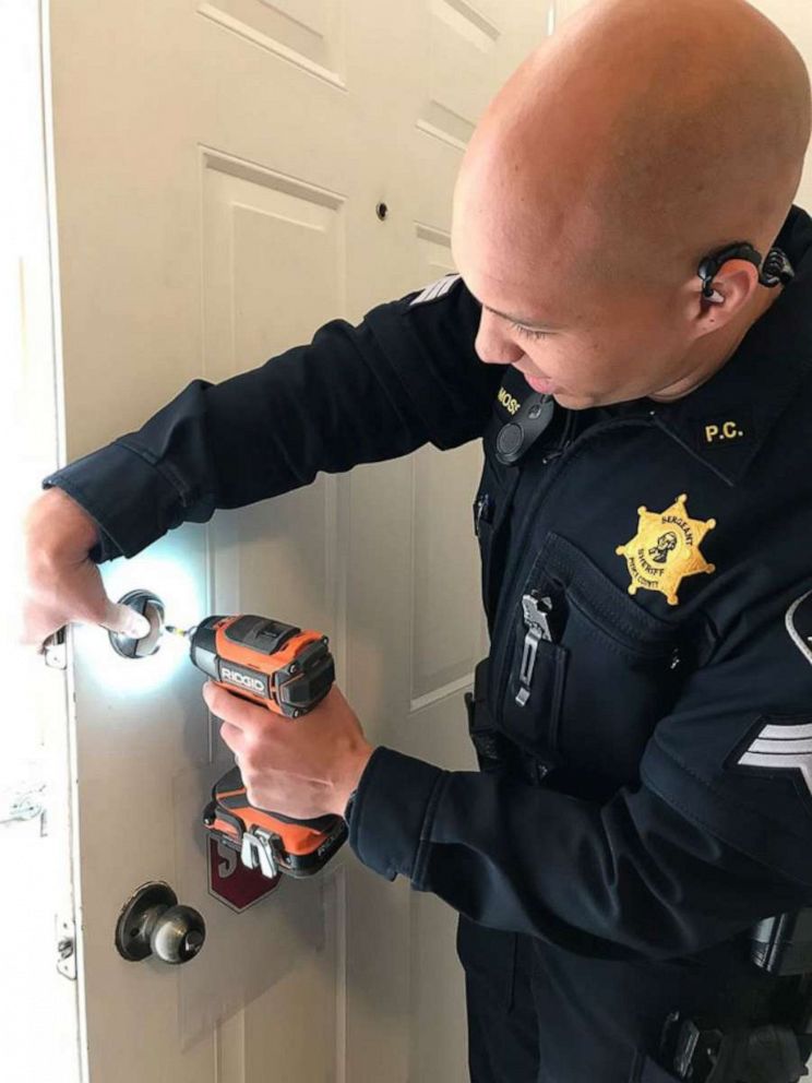 PHOTO: A Pierce County Sheriff's deputy installs a new lock at the victim's home after a woman posing at a newborn photographer entered her her home and stole her keys.
