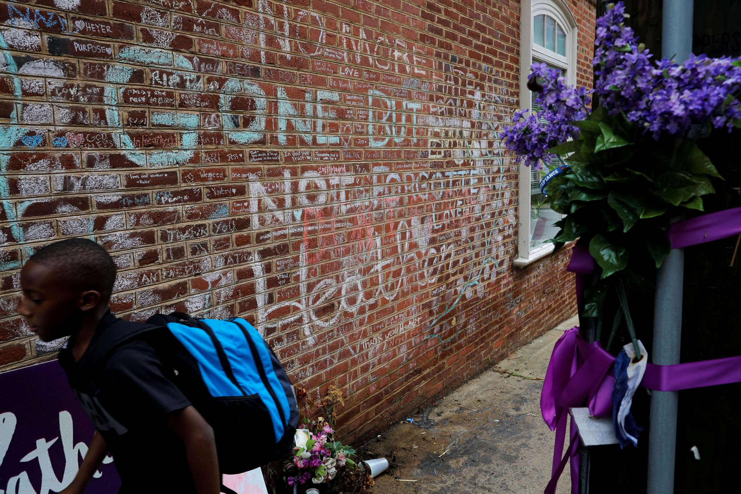 PHOTO: A boy passes tributes written at the site where Heather Heyer was killed during the 2017 white-nationalist rally in Charlottesville, Va., Aug. 1, 2018.