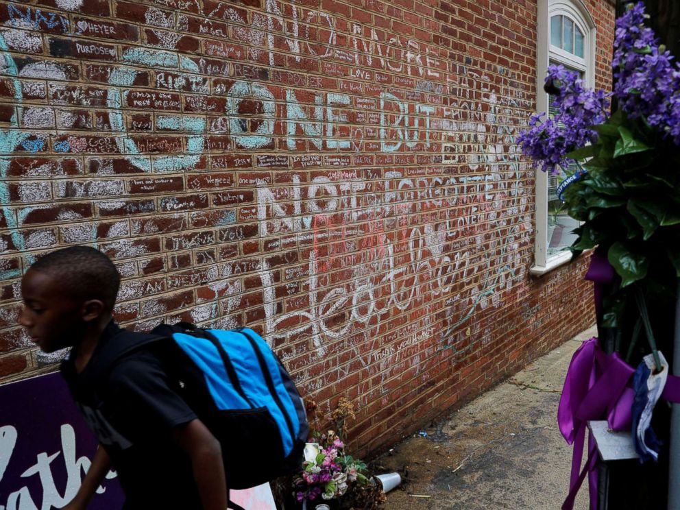 PHOTO: A boy passes tributes written at the site where Heather Heyer was killed during the 2017 white-nationalist rally in Charlottesville, Va., Aug. 1, 2018.
