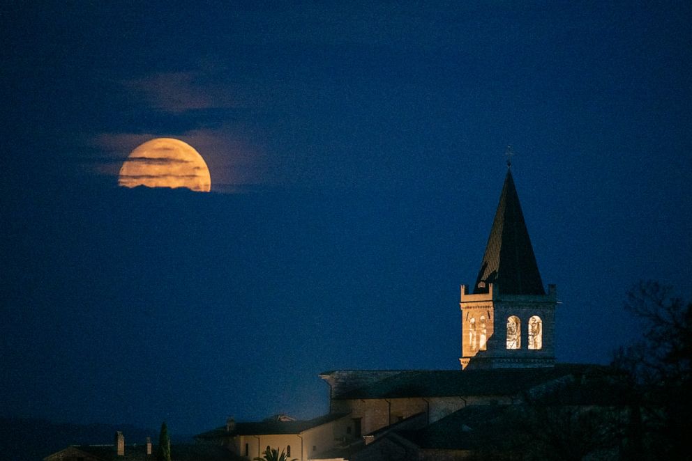 PHOTO: The Full Pink moon sets behind Santa Maria Maggiore church in Spello, Umbria, Italy, on April 15, 2022. 
