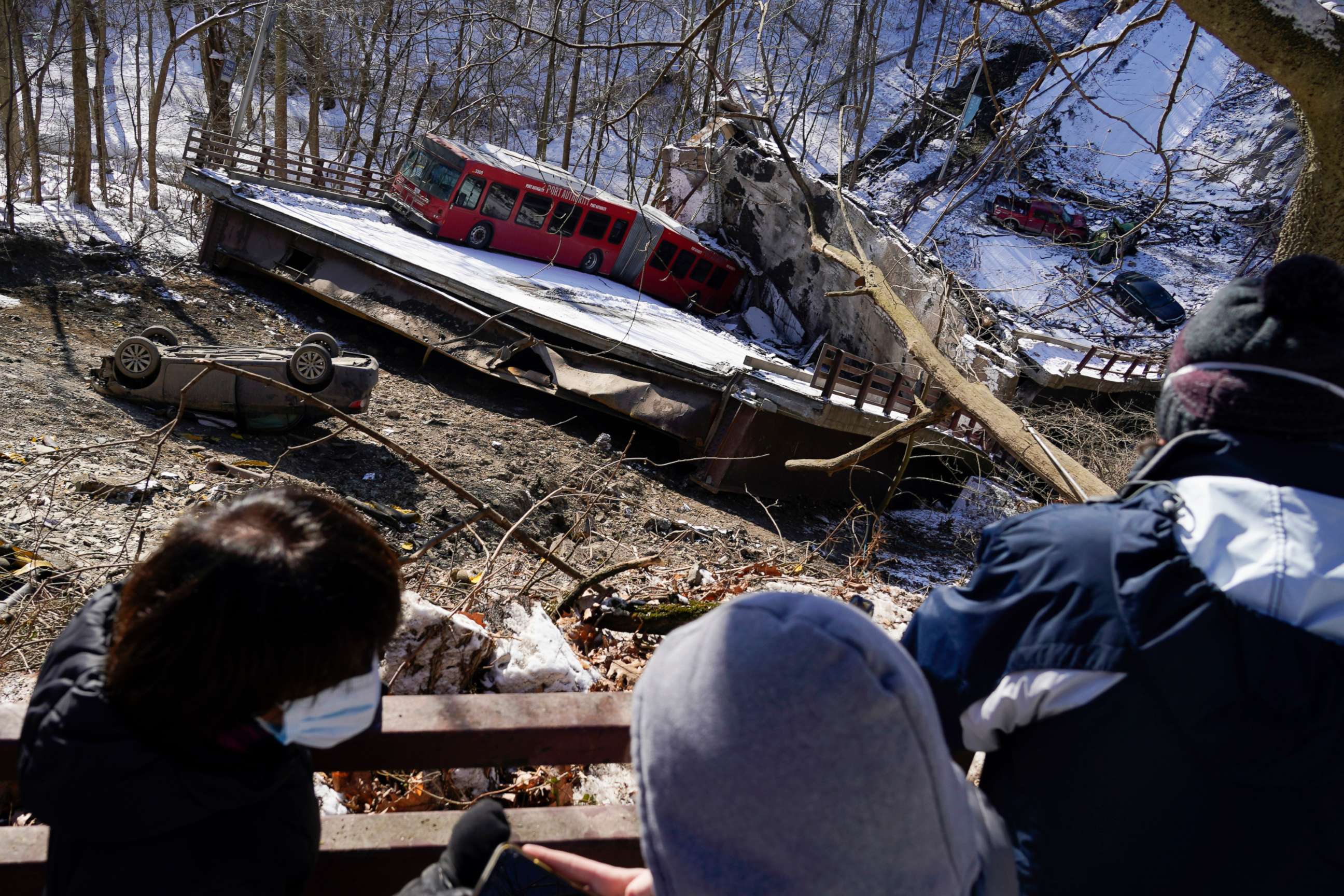 PHOTO: Onlookers look at the bus and vehicles below after Friday's bridge collapse Saturday, Jan. 29, 2022, in Pittsburgh.