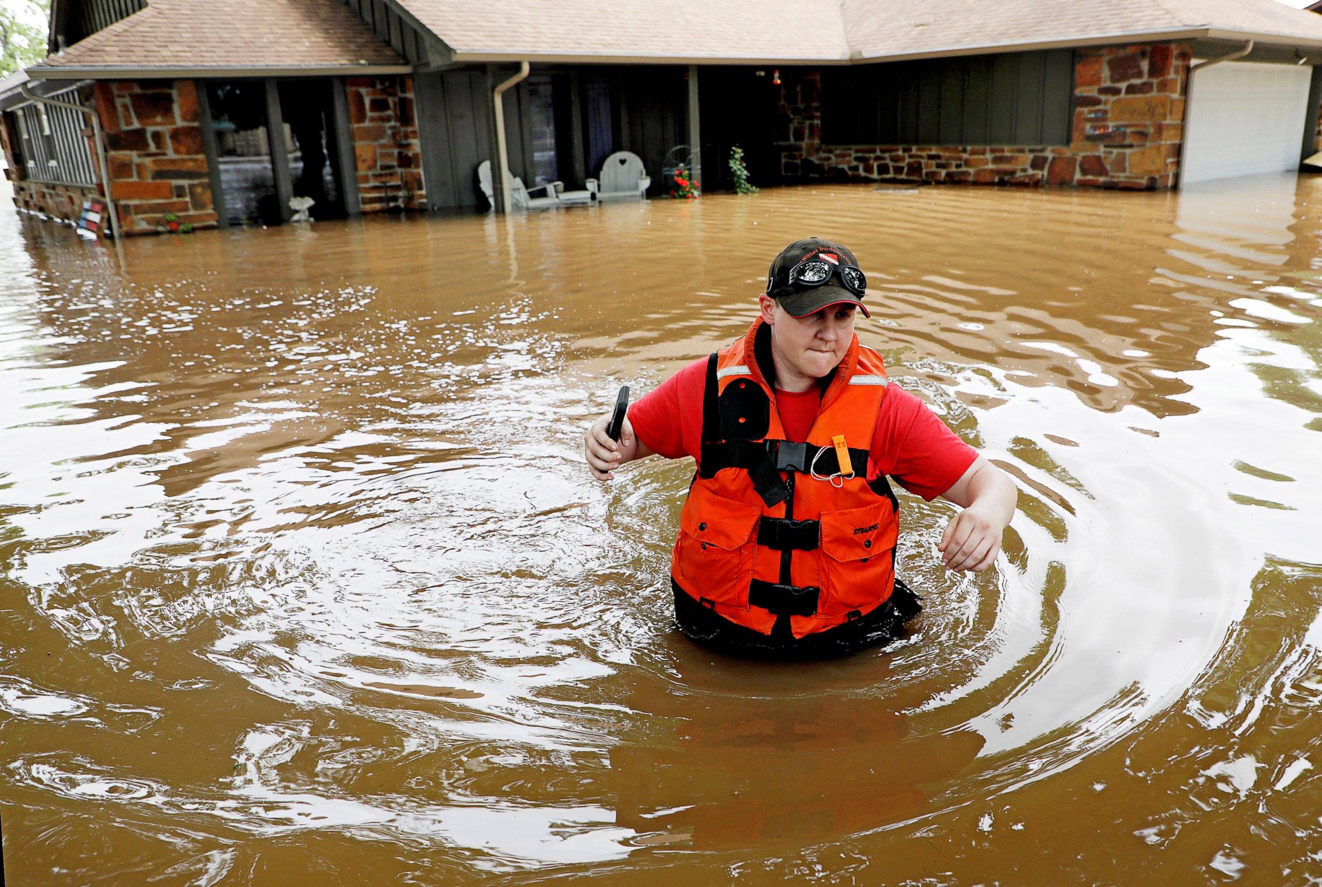 PHOTO: Tulsa County Sheriff's Deputy Miranda Munson makes her way back to a fan boat after checking a flooded house for occupants in the Town and Country neighborhood in Sand Springs, Okla., Thursday, May 23, 2019.