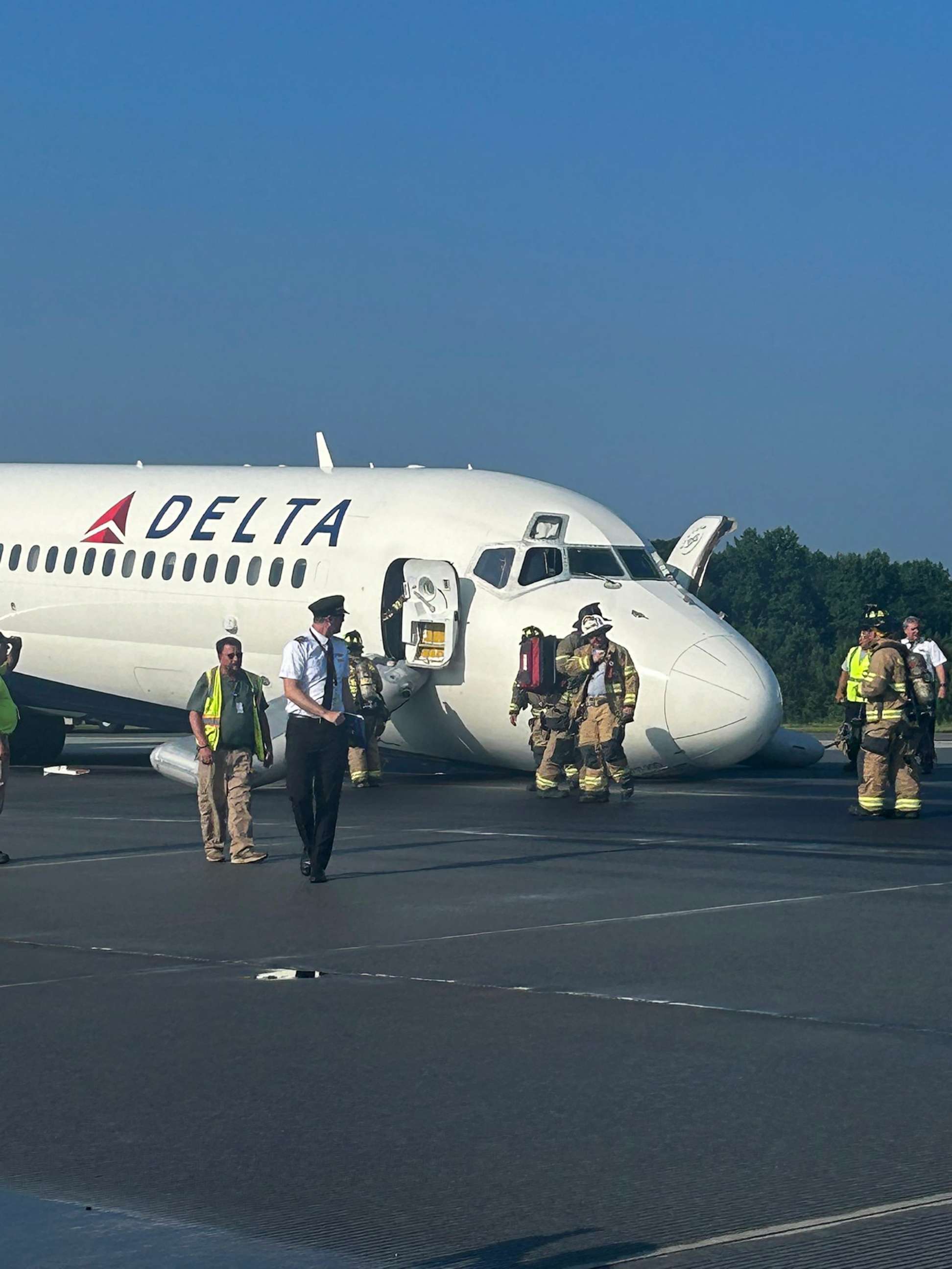 PHOTO: Firefighters attend to a passenger plane that landed at Charlotte Douglas International Airport in N.C. without its landing gear extended, June 28, 2023.