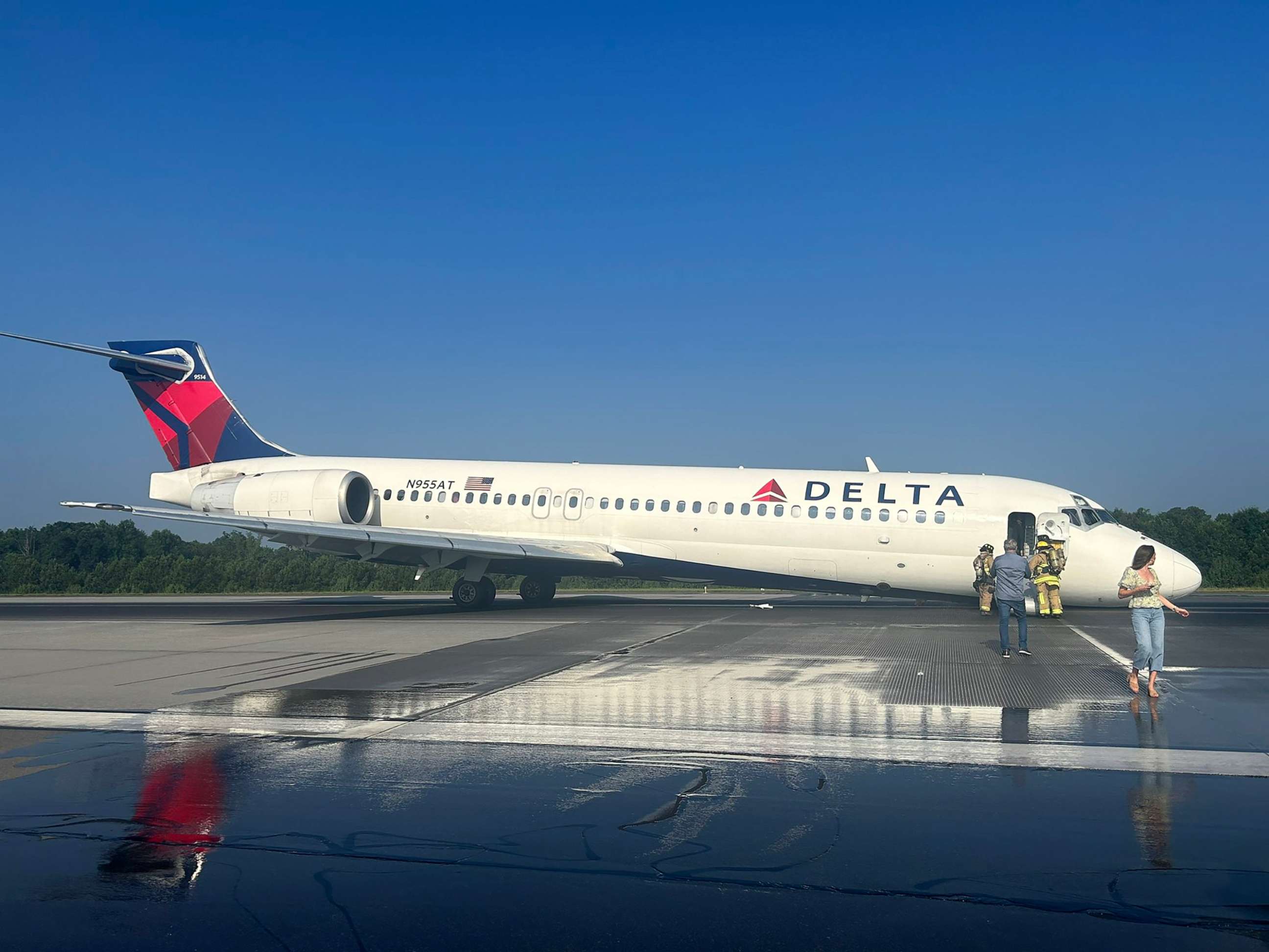PHOTO: Firefighters attend to a passenger plane that landed at Charlotte Douglas International Airport in N.C. without its landing gear extended, June 28, 2023.