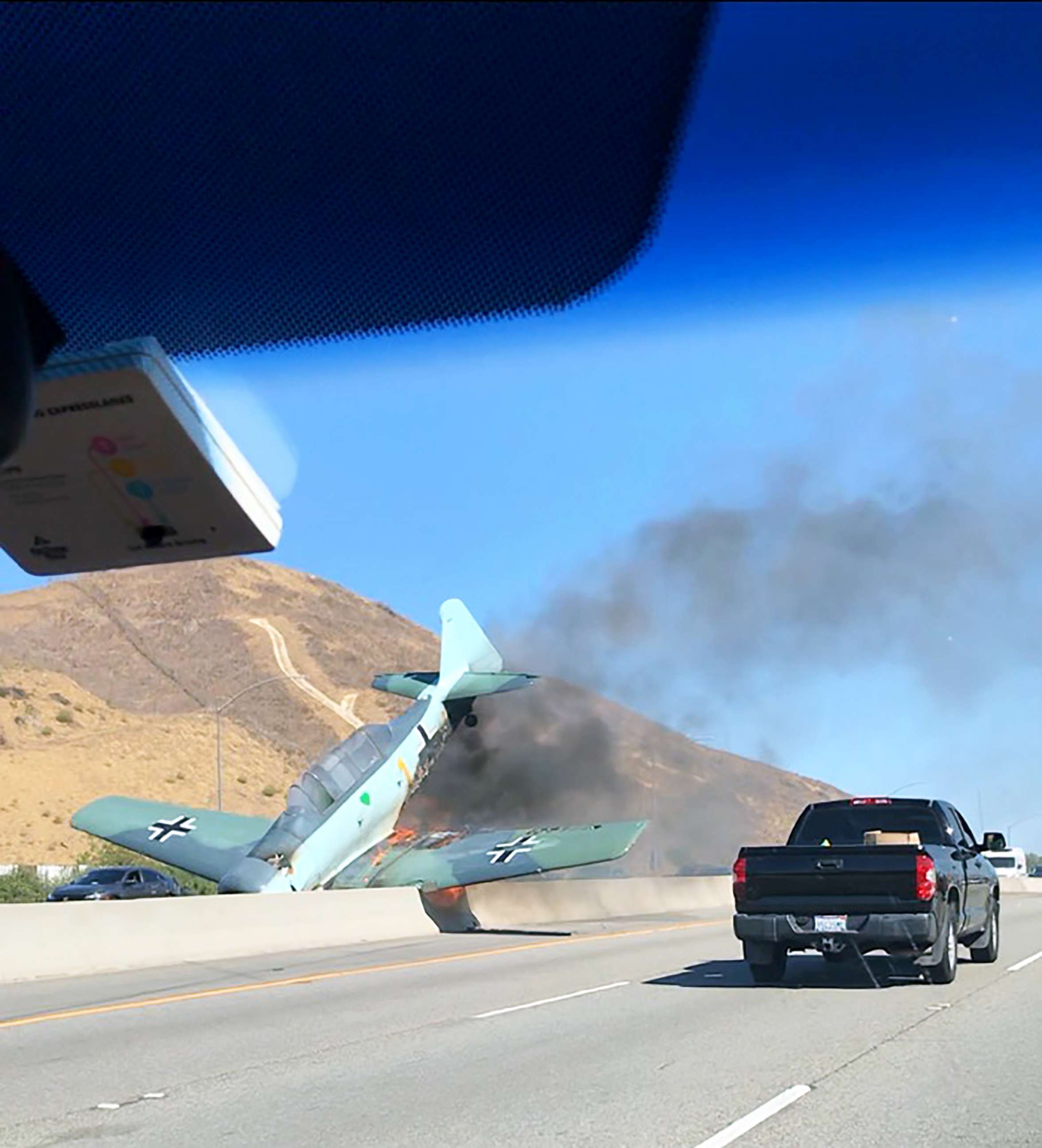 Vintage plane erupts in flames after crashing onto freeway in