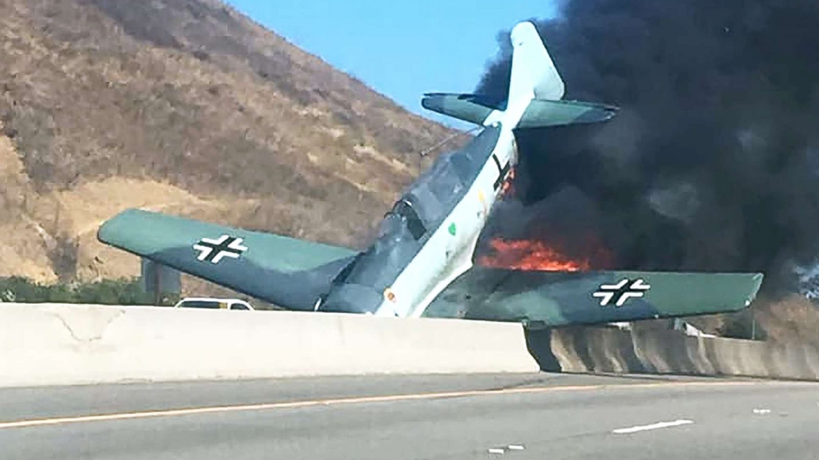 Vintage plane erupts in flames after crashing onto freeway in