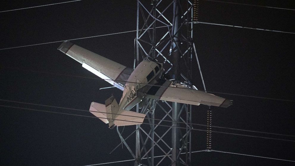 PHOTO: A small plane rests on live power lines after crashing, Sunday, Nov. 27, 2022, in Montgomery Village, a northern suburb of Gaithersburg, Md. 