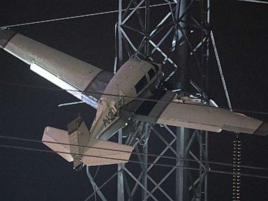 2 trapped in small plane after it strikes high-tension power lines