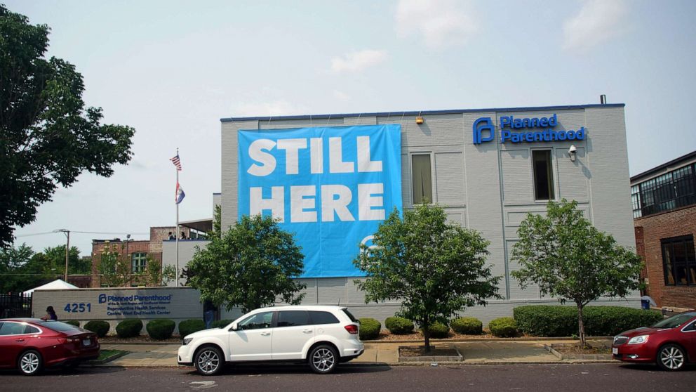 PHOTO: A banner stating "STILL HERE" hangs on the side of the Planned Parenthood Building after a judge granted a temporary restraining order on the closing of Missouri's sole remaining Planned Parenthood clinic in St. Louis, May 31, 2019.